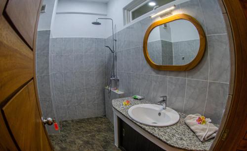 a bathroom with a sink and a mirror at Senggigi Homes & Apartments in Senggigi 