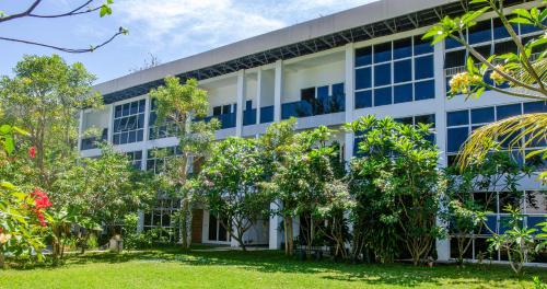 an office building with trees in front of it at Senggigi Homes & Apartments in Senggigi 