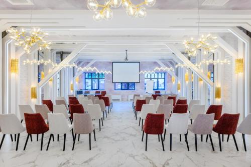 a conference room with chairs and a projection screen at Mercure Tokaj Center in Tokaj
