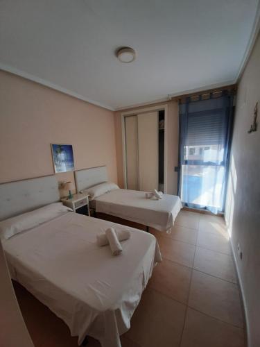 a hotel room with two beds and a window at Plaza Mayor 2 bedroom Apartment in Calpe