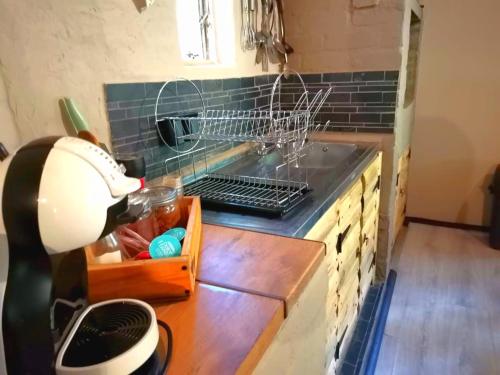 a kitchen counter with a drying rack on a stove at Cango Retreat Breathe in Oudtshoorn