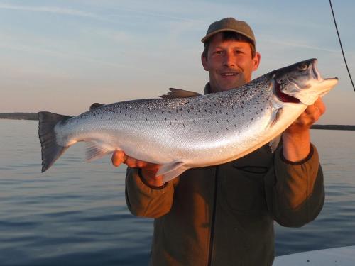 a man holding up a fish he is holding at Exclusive House in Olofström