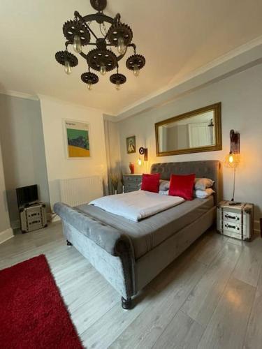 a bedroom with a large bed with red pillows at The Vault – cosy apartment in central Hove / Brighton in Brighton & Hove