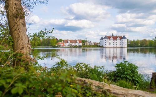 a large building on the water in front of a lake at Ferienwohnung Pape in Glücksburg