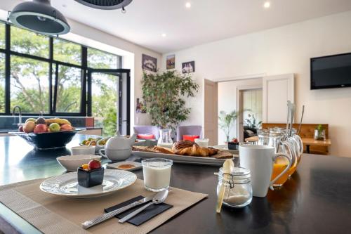 a dining room with a table with food on it at Escale Rochelaise B&B, SPA bain nordique et sauna tonneau in La Rochelle