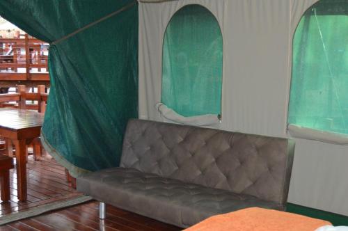 a couch in a room with a tent at Luxury Tented Village @ Urban Glamping in St Lucia