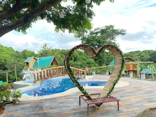 une sculpture cardiaque assise sur un banc à côté d'une piscine dans l'établissement Don Roberto's Kubo Resort, à Nasugbu