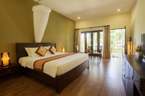 ein Schlafzimmer mit einem großen Bett und einem großen Fenster in der Unterkunft Diamond Bay Resort & Spa in Nha Trang