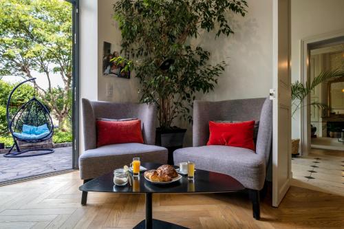 Duas cadeiras e uma mesa de centro numa sala de estar em Escale Rochelaise B&B, SPA bain nordique et sauna tonneau em La Rochelle