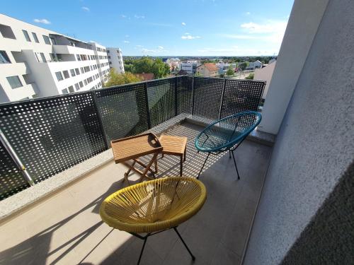 札格雷布的住宿－Apartman ARIA，大楼内的阳台配有两把椅子和长凳