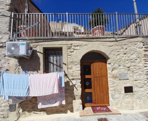 un edificio con ropa colgada en una línea de ropa y un balcón en Sognando nel borgo, en Rocca Imperiale