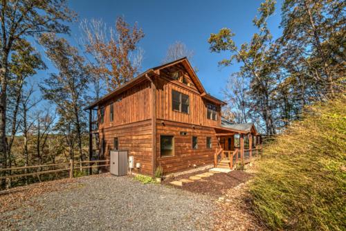 a log cabin in the woods with a driveway at Highland Harmony in Ellijay