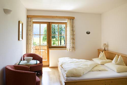 RattendorfにあるHansbauerhofのベッドルーム1室(ベッド1台、椅子、窓付)