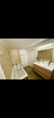 une salle de bain avec une baignoire et un lavabo dans l'établissement Maisons refait à neuf proche centre ville., à Fleury-sur-Orne