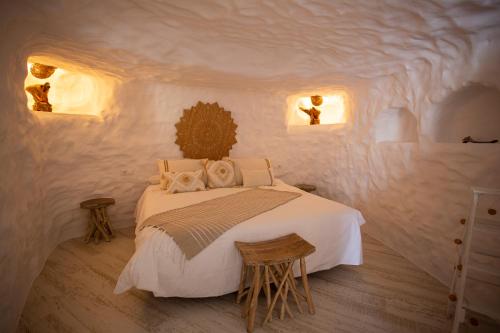 a bedroom with a bed in a white room at Complejo Cuevas Otto in Baza