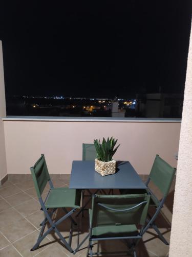 a table and chairs on a balcony with a window at Appartamento Minerva in Palo del Colle