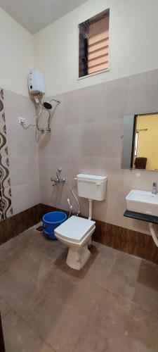 a bathroom with a toilet and a sink at Sneha Farm House in Kudāl