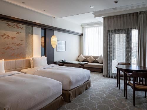 a hotel room with two beds and a couch at Okinawa EXES Naha in Naha