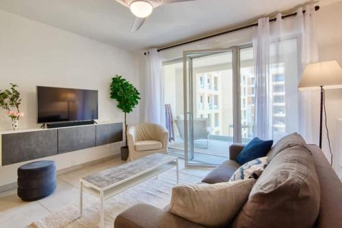 a living room with a couch and a tv at Le Fonction, meublé 4 étoiles, avec parking boxé in Aix-en-Provence