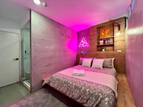 a bedroom with a bed with pink lights on it at 闆娘公寓 in Kaohsiung
