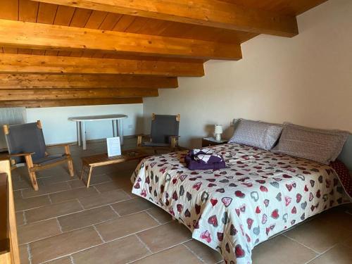 een slaapkamer met een bed en een tafel en stoelen bij Alloggio con piscina a Sorso 3 kilometri dal mare in Sorso