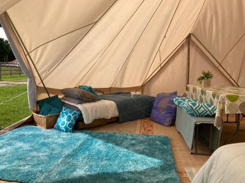 a tent with two beds and a table in it at Bell Tent Village Sleeps up to 16! in Bartley