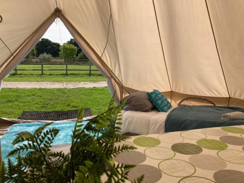 a couple of people sleeping in a tent at Bell Tent Village Sleeps up to 16! in Bartley
