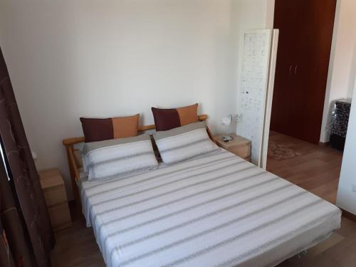 1 dormitorio con 1 cama con sábanas blancas en Appartamentino Sogno di Circe en San Felice Circeo