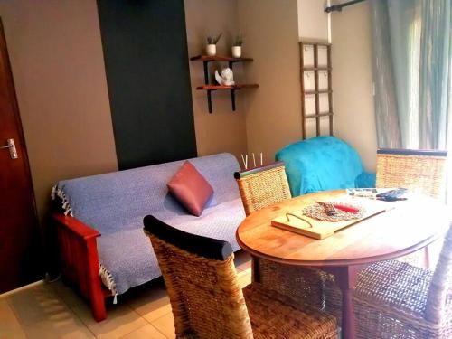 a room with a table and a bed and a table and chairs at Unit Blessed in Oudtshoorn