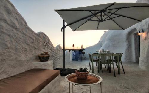 une terrasse avec une table et un parasol dans l'établissement Complejo Cuevas Otto, à Baza