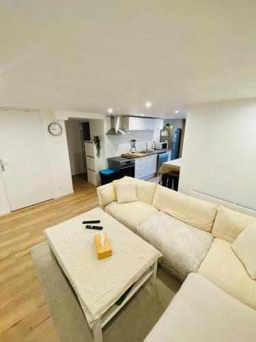 un salon avec un canapé et une table dans l'établissement Maisons refait à neuf proche centre ville., à Fleury-sur-Orne