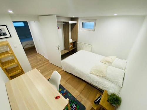 une petite pièce avec un lit et une table dans l'établissement Maisons refait à neuf proche centre ville., à Fleury-sur-Orne