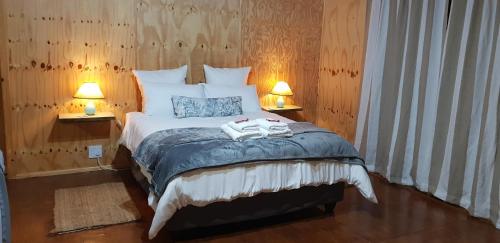 a bedroom with a bed with two towels on it at Lekkerkry in Plettenberg Bay