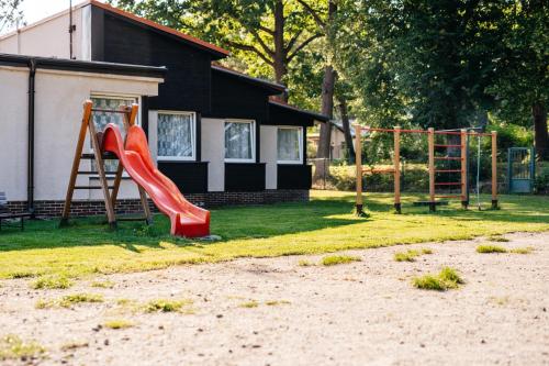 a playground with a slide in front of a house at Resort Lesák in Chlum u Třeboně