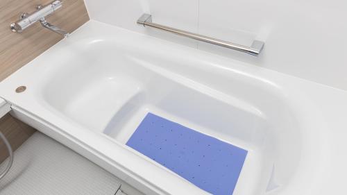 a bathroom with a white tub with a blue sink at JR-East Hotel Mets Kamakura Ofuna in Kamakura