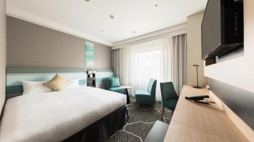 a hotel room with a bed and a television at JR-East Hotel Mets Kamakura Ofuna in Kamakura