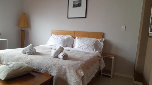 1 dormitorio con 1 cama con toallas en Limbila House, en Ciudad del Cabo