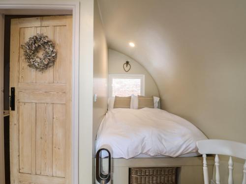 a small bedroom with a bed and a door at Willow in Uttoxeter
