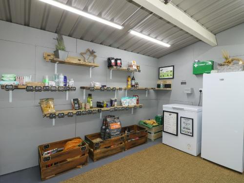 Zimmer mit Regalen an der Wand und einem Kühlschrank in der Unterkunft Willow in Uttoxeter