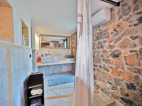 y baño con paredes de piedra, ducha y cortina de ducha. en Casa Ginestra en Lerici