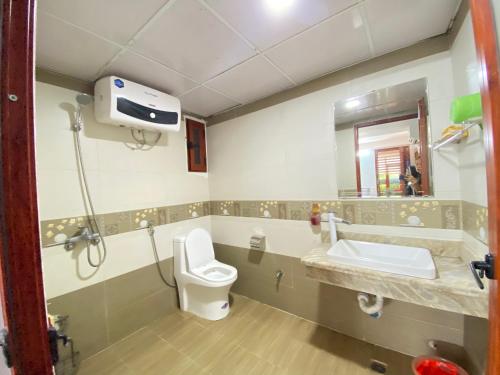 La salle de bains est pourvue de toilettes, d'un lavabo et d'un miroir. dans l'établissement Mint Homestay - Thanh Hóa, à Thanh Hóa