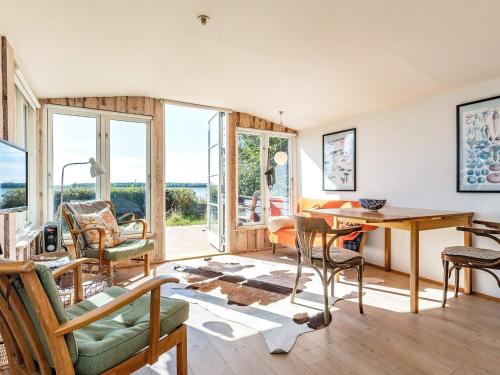 - un salon avec une table et des chaises dans l'établissement Holiday home Bogense II, à Bogense