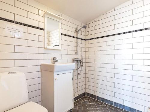 La salle de bains blanche est pourvue de toilettes et d'un lavabo. dans l'établissement Holiday home Bogense II, à Bogense