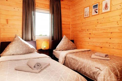a bedroom with two beds in a log cabin at holiday home, Gaski in Gąski