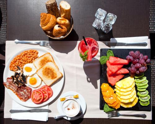 a breakfast table with a plate of eggs bread and fruit at Hotel Ses Figueres in Talamanca