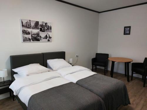 1 dormitorio con 2 camas, mesa y sillas en Hotel Vallis, en Vaals