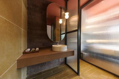 a bathroom with a sink and a mirror at East India House in Gorai