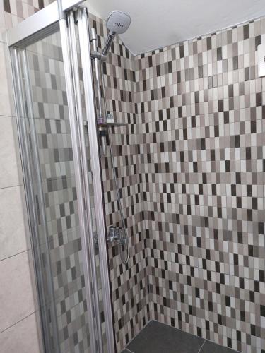 a bathroom with a shower with brown and gray tiles at Secret garden no:01 in Mağusa