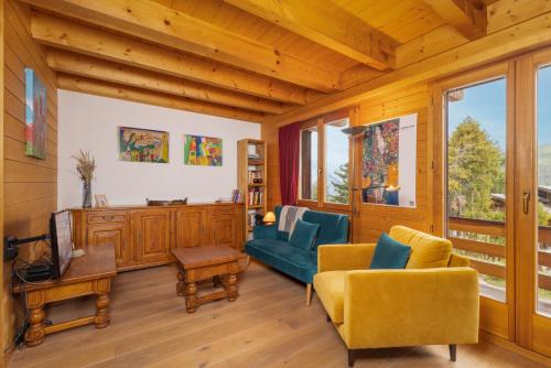a living room with yellow chairs and a blue couch at Chalet Mouettes in Riddes