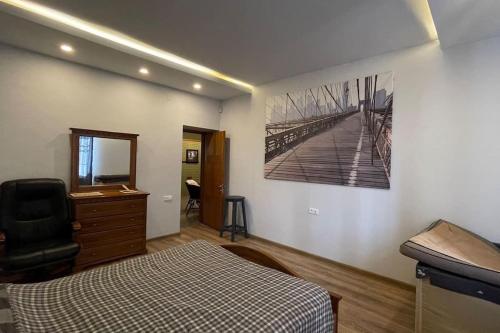 OganavanにあるCheerful 3-bedroom villa with poolのベッドルーム1室(ベッド1台付)が備わります。壁に絵が飾られています。
